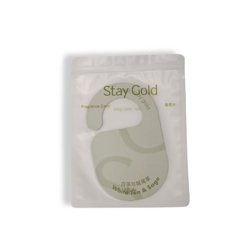 Sealed pouch packaging of Stay Gold white tea and sage hanging air freshener